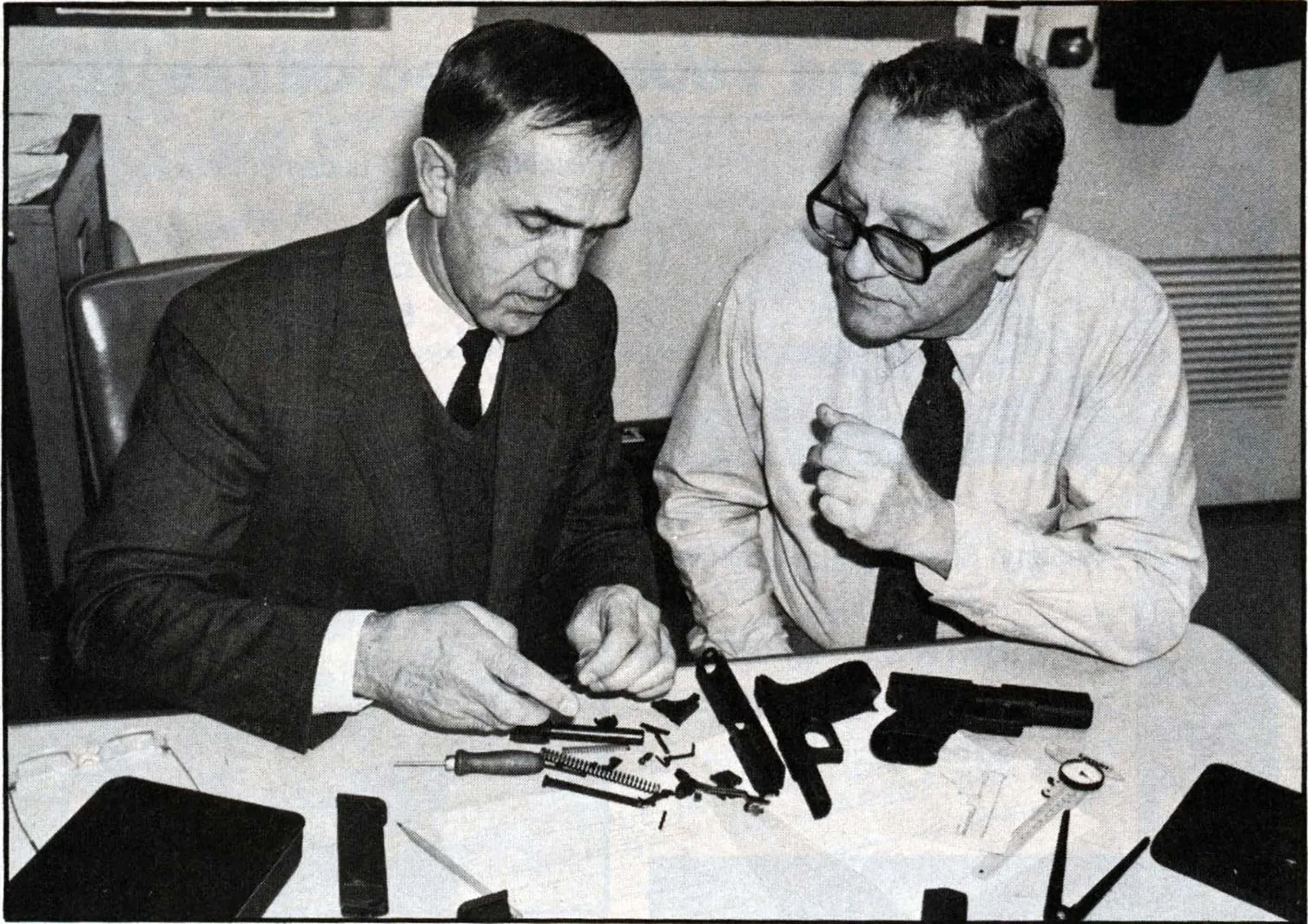 Gaston Glock examining a disassembled pistol with an NRA staffer