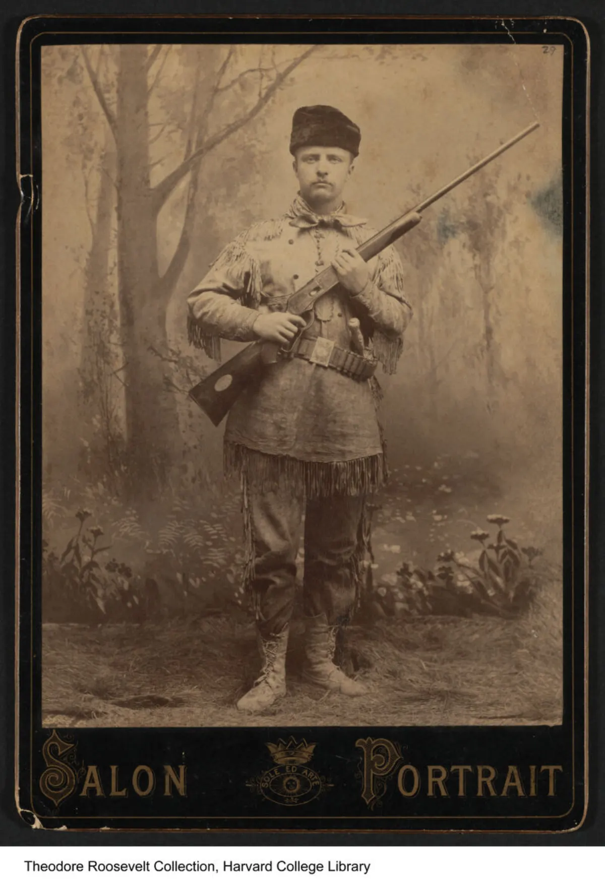 Theodore Roosevelt in buckskin holding a rifle
